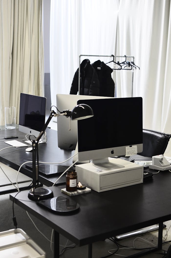 Sleek modern office with computers, lamp, and minimalistic design elements.